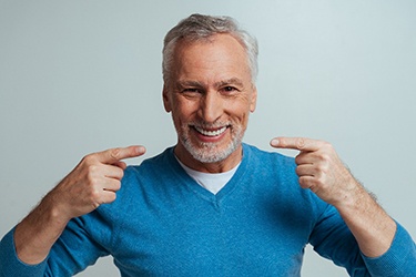 Happy senior man pointing at his teeth