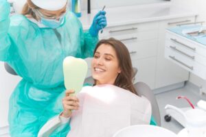 Patient admiring her smile in the mirror after full mouth reconstruction